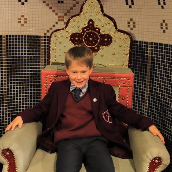 a child from a private school in Bucks sitting on a throne