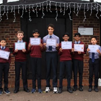 group of school boys holding up certificates