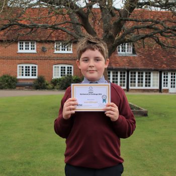 1 student holding his Junior Maths challenge certificate