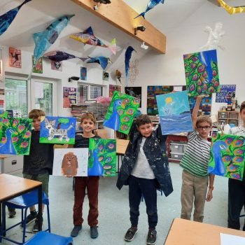 Boys holding art work they have completed