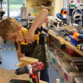 a child using an electric drill at a boys school in Chesham