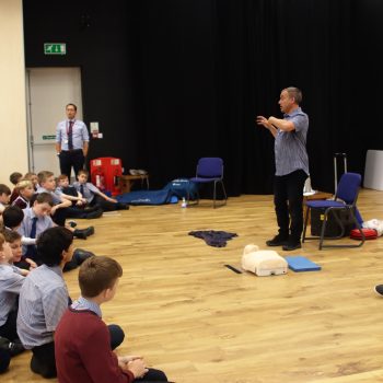The first aid teacher talks to the class as he speaks about CPR and safety