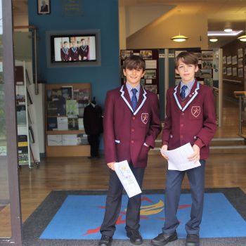 2 students at the front door of the school