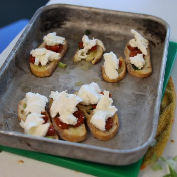 Students adding bruschetta to a serving tray