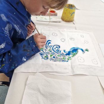 student painting a peacock