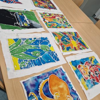 a row of paintings completed by students