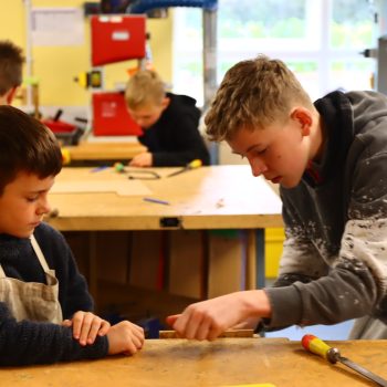 2 students working together on making wooden sculptures
