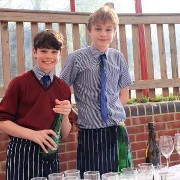 2 students serving drinks