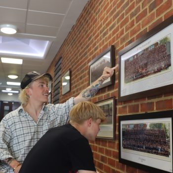 Alumni looking at previous students on the walls