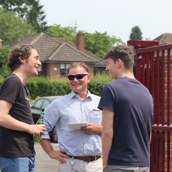 Alumni having a chat by a red gate