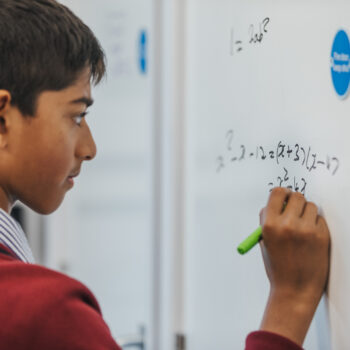student writing on a whiteboard