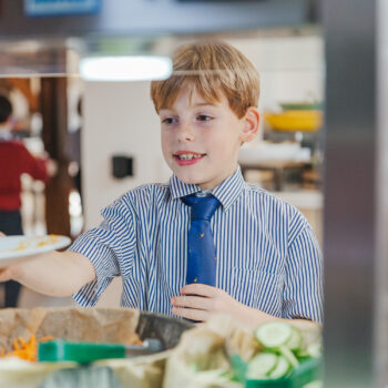 boy receiving food from cafeteria